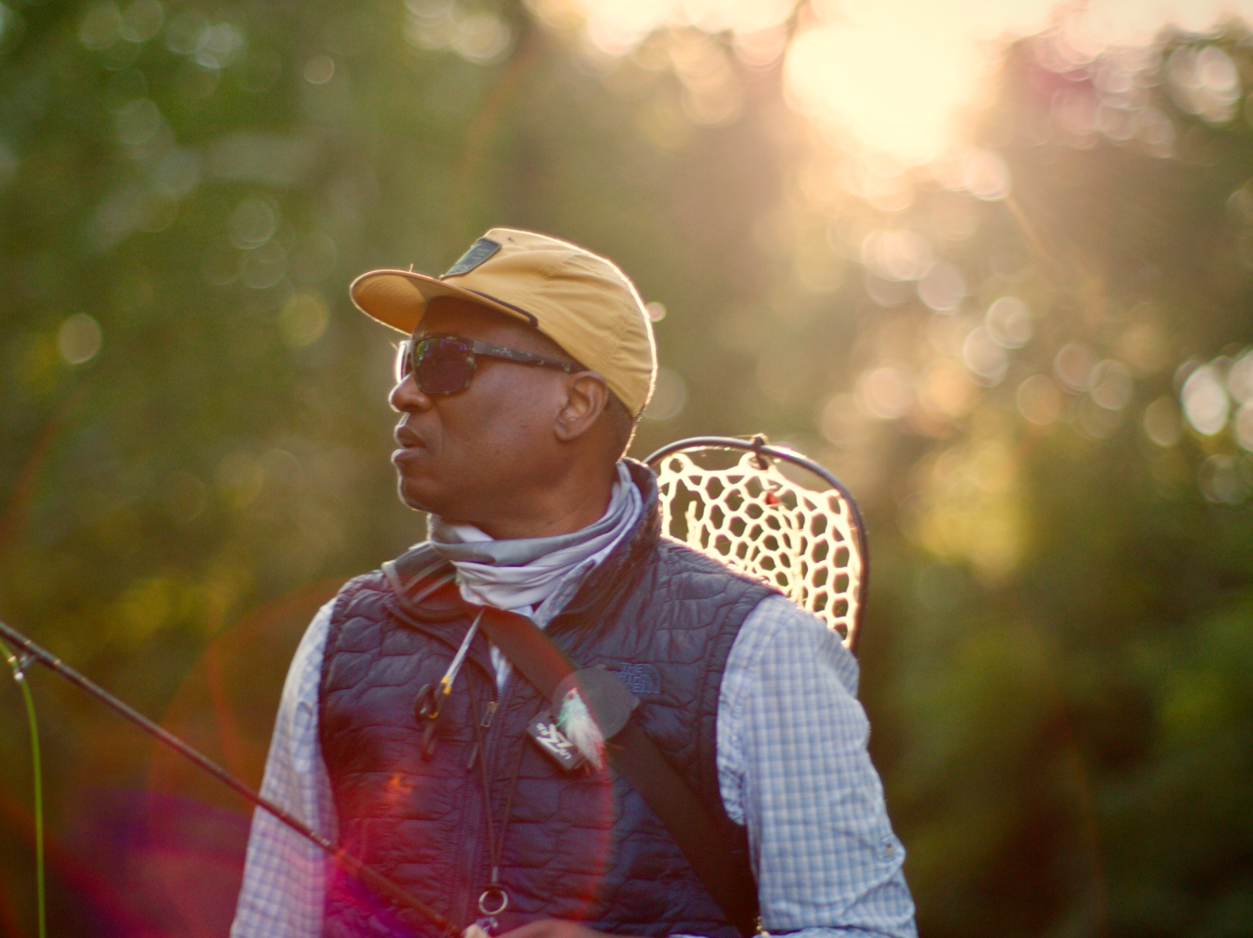 Al on the bank at golden hour with rod, vest and net