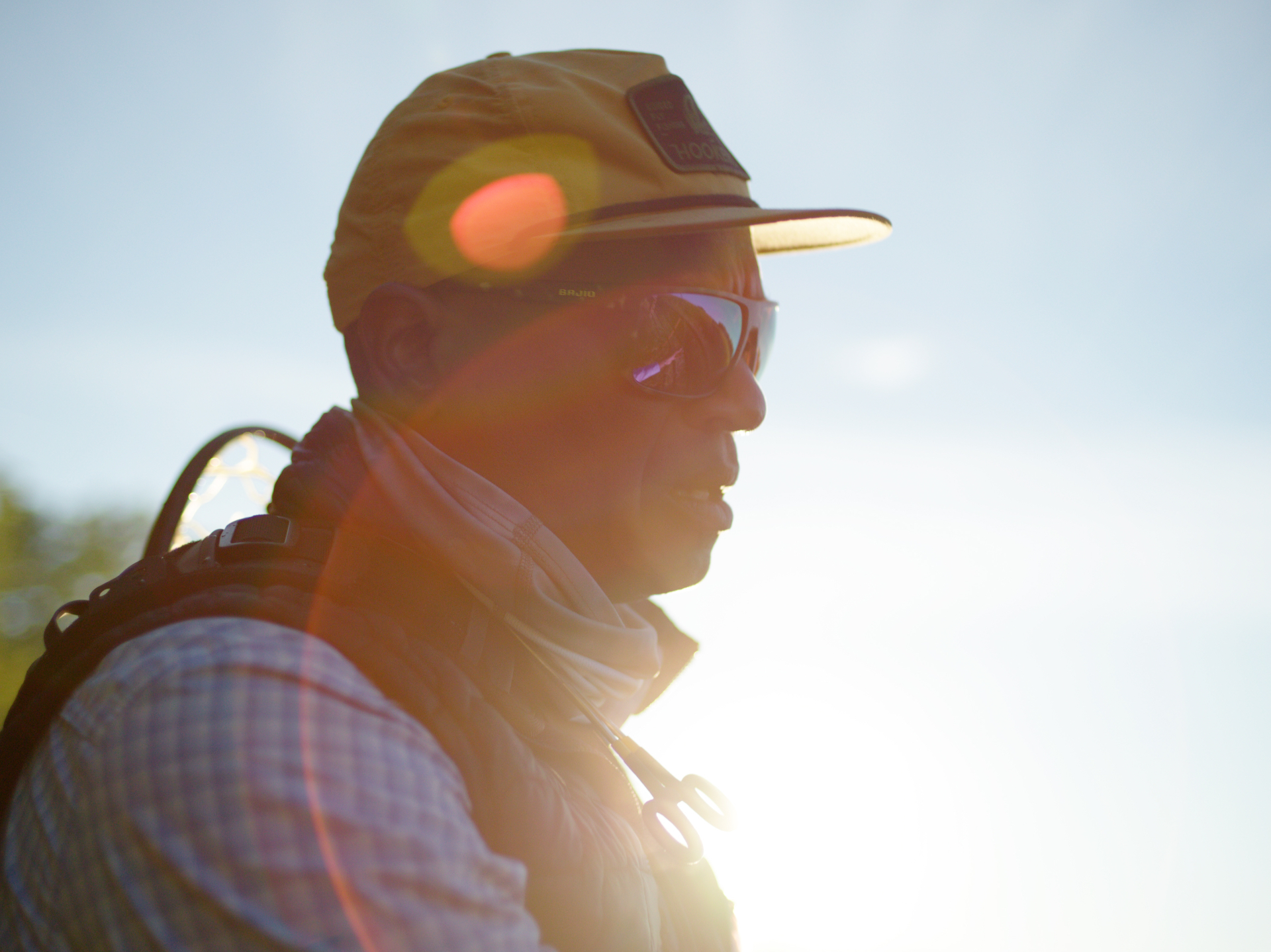 Backlit silhouette of Al with sun flare across the brim of his cap